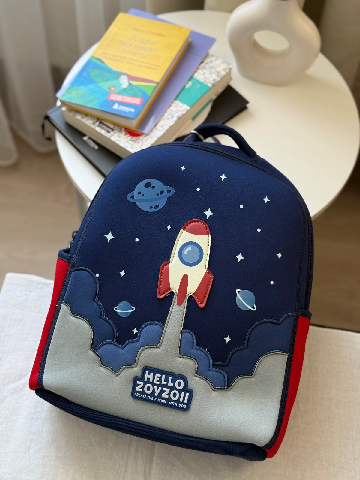 Mochila escolar de niños con diseño de cohete entre nubes