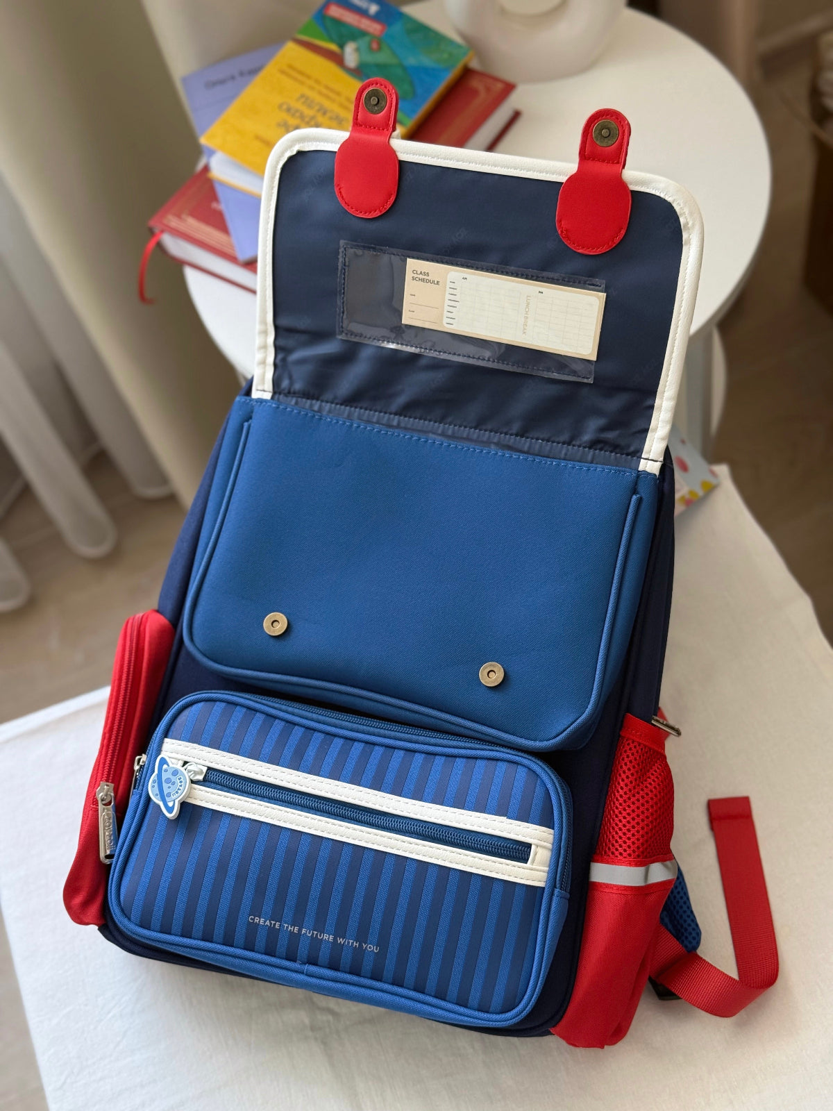 Zoy Zoii mochila escolar azul con detalles rojos, diseño clásico con bolsillos frontales, cremallera resistente y correas acolchadas, ideal para niños en la escuela primaria