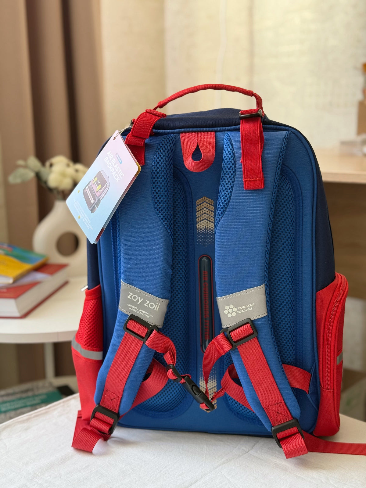 Zoy Zoii mochila escolar azul con detalles rojos, diseño clásico con bolsillos frontales, cremallera resistente y correas acolchadas, ideal para niños en la escuela primaria