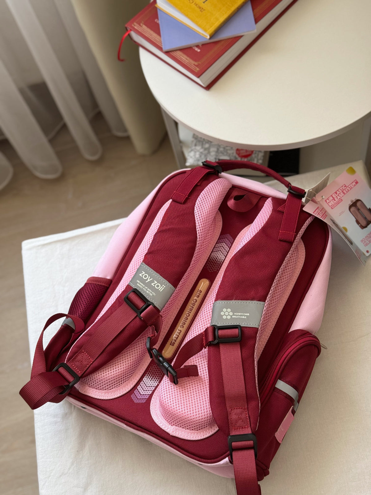 Mochila escolar Zoy Zoii para niñas en color rojo y rosa con tirantes acolchados, bolsillo frontal con cremallera y diseño práctico para uso diario