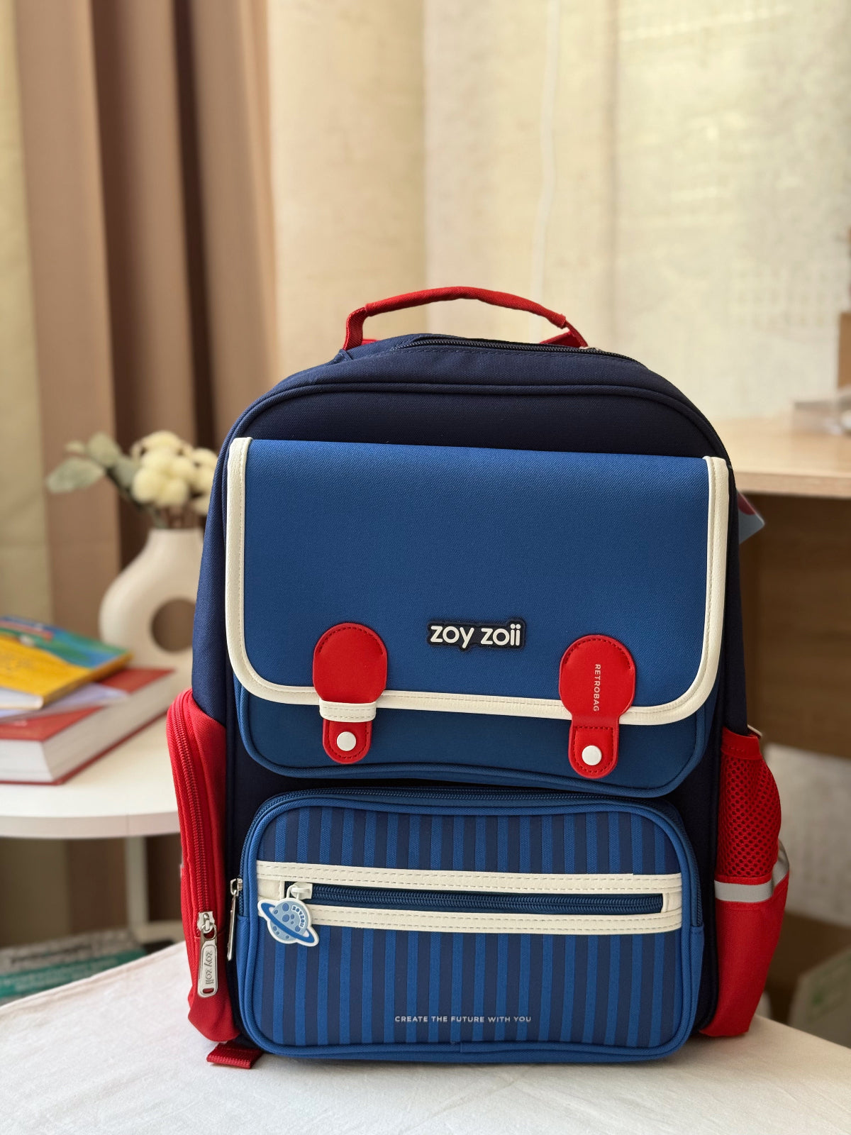 Zoy Zoii mochila escolar azul con detalles rojos, diseño clásico con bolsillos frontales, cremallera resistente y correas acolchadas, ideal para niños en la escuela primaria