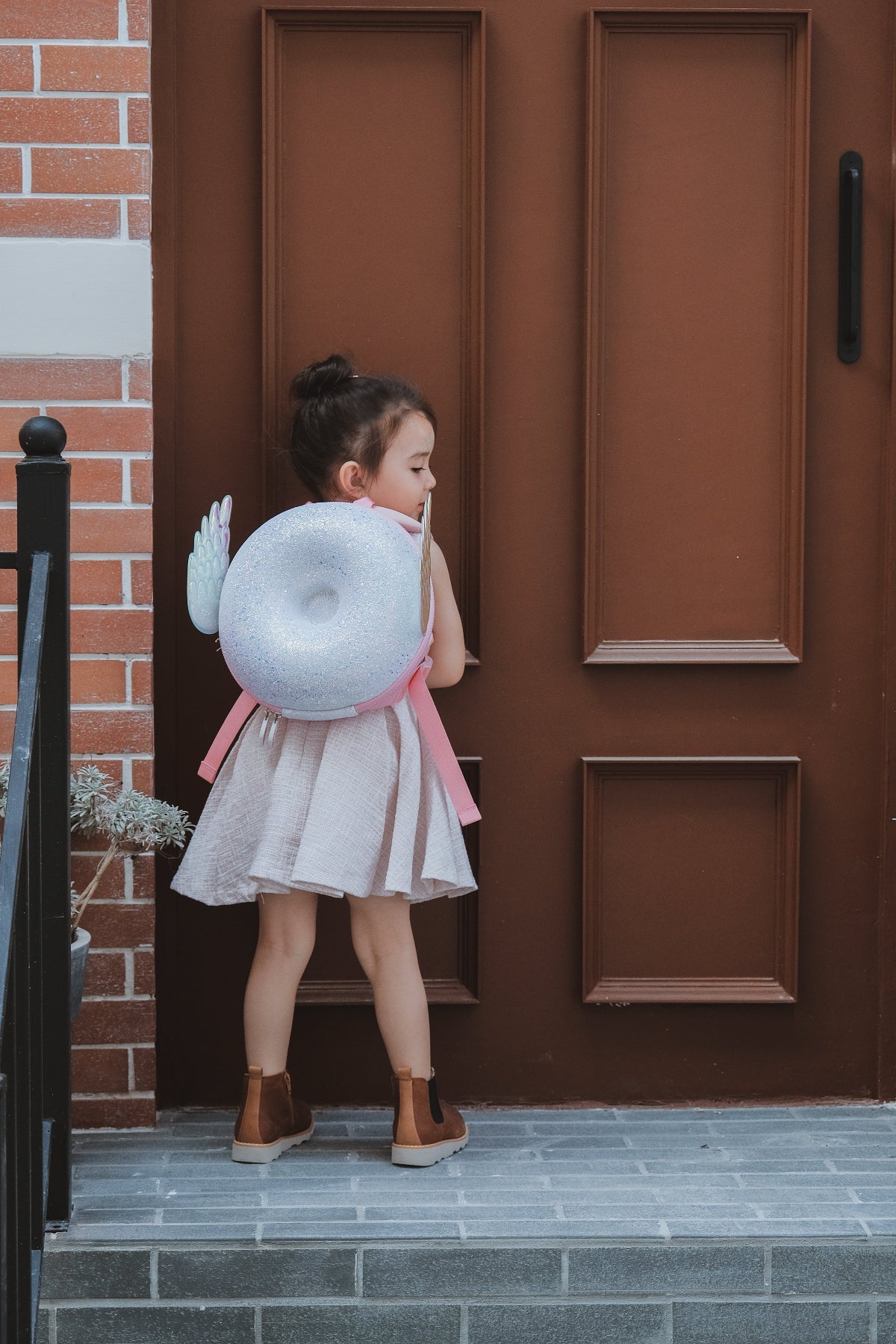 Mochila Zoy Zoii rosa con alas decorativas y acabado brillante.